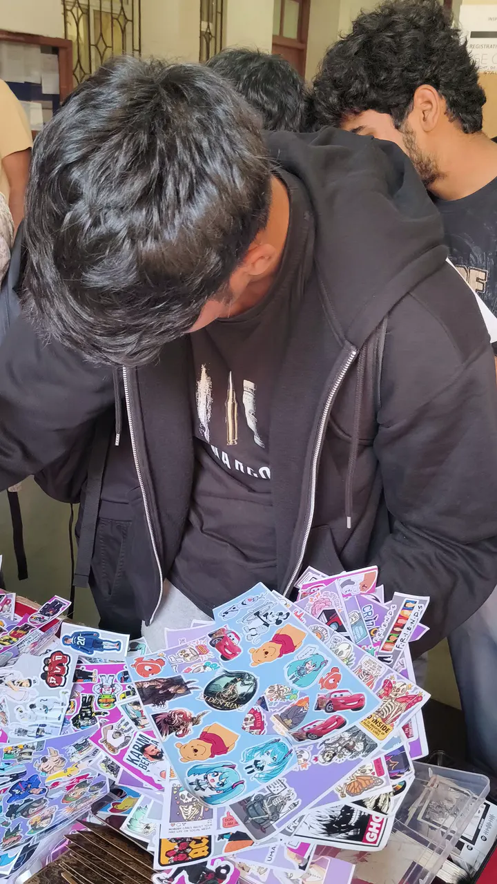 Students crowding a Stix N Vibes stall, picking stickers and posters